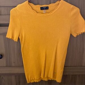 Tahari shirt plain yellow with a logo on the front at the bottom of the shirt
